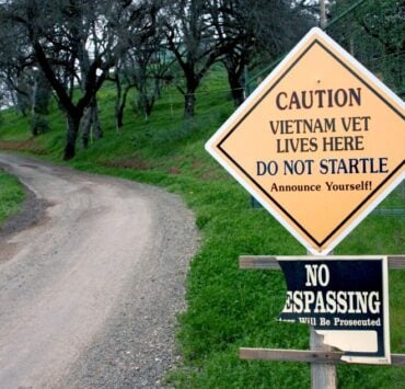 cannabis world news .image of road and sign that says Caution Vietnam Vet Lives Here and caution