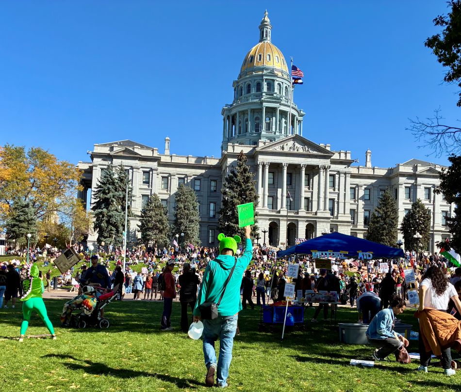 cannabis world news commentary image of man holding sign in front of state capitol bulding