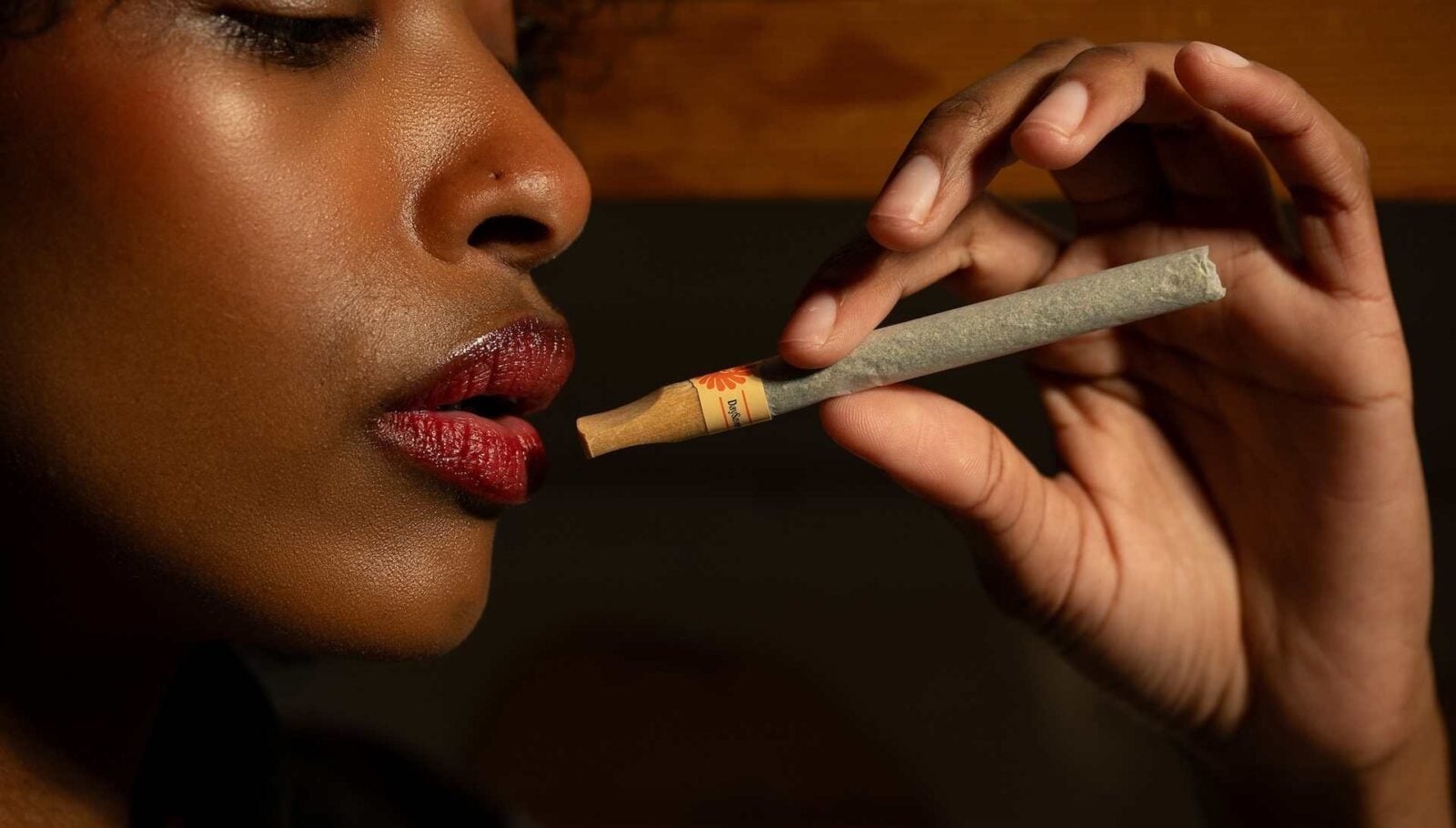 cannabis world news African American woman holding a pre-roll cannabis joint
